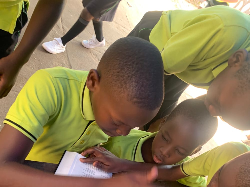 Two kindergarten friends sharing a reading book
